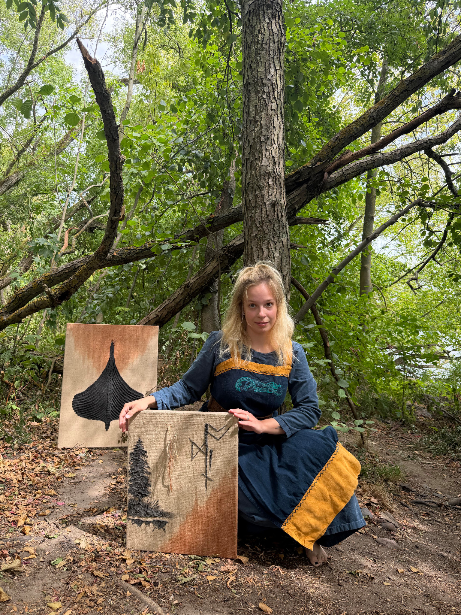 Künstlerin Svea Gwendolin im Wald mit zwei eigenen Arbeiten