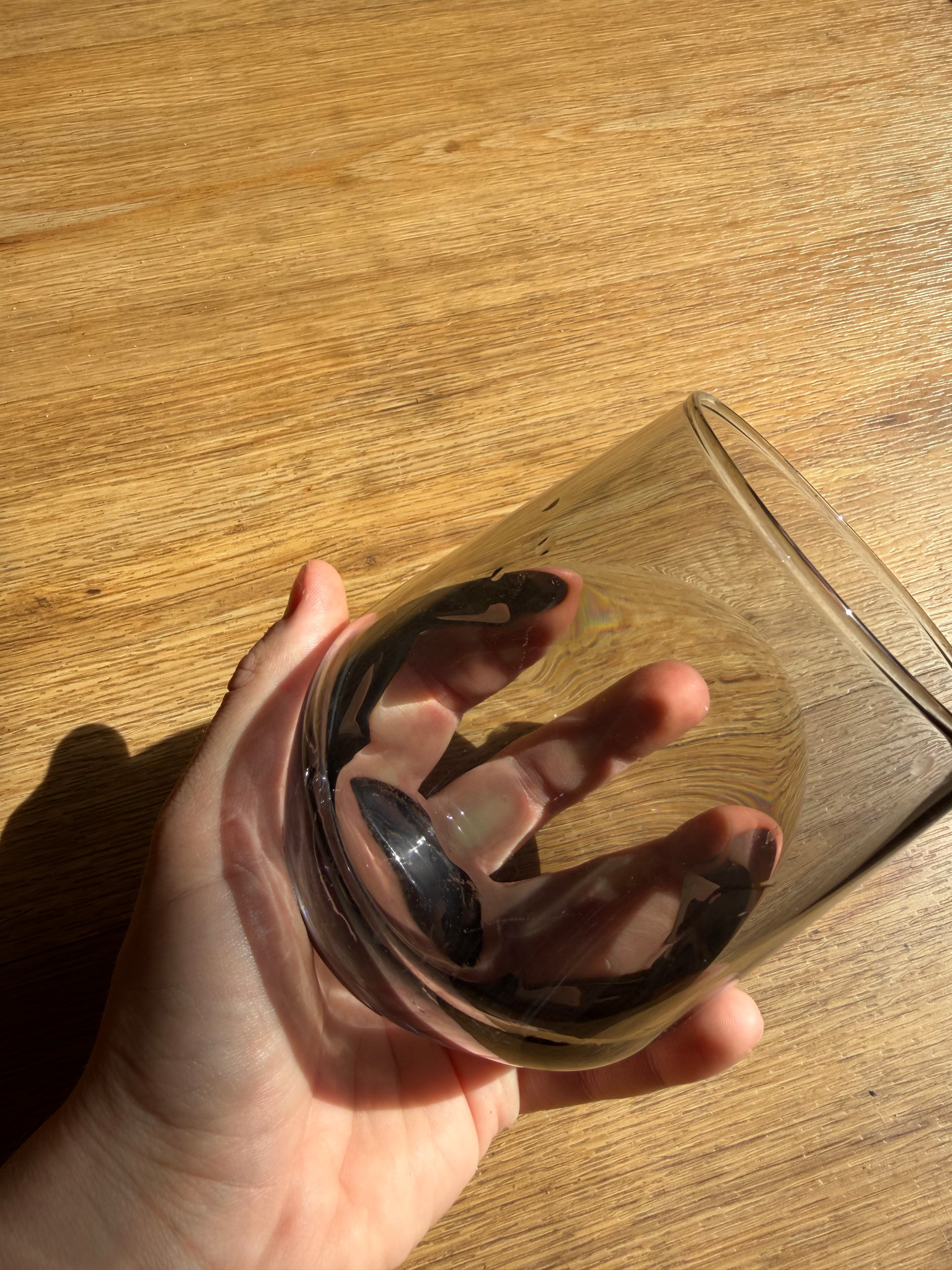Getöntes Glas in einer Hand bei warmer Sonne